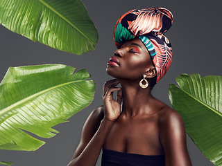 Image showing Black woman in African turban, fashion with leaves and beauty with makeup on studio background. Natural cosmetics, nature aesthetic and female model with traditional head wrap, creativity and style