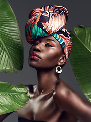 Image showing Black woman in traditional turban, fashion with leaves and beauty with makeup on studio background. Natural cosmetics, nature aesthetic and female model with African head wrap, creativity and style