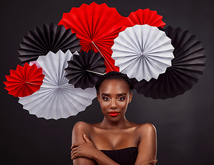 Image showing Origami fans, portrait and a black woman for culture isolated on a black background in a studio. Paper, creative and an African model with art design for tradition, color and Japanese celebration