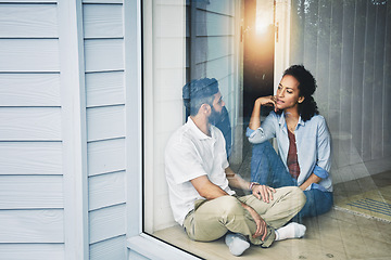 Image showing Couple, relax and talking while sitting by window enjoying morning or day together on floor at home. Man and woman relaxing in relationship, discussion or conversation for weekend or holiday indoors