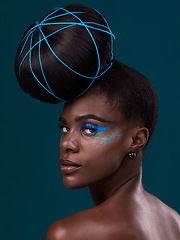 Image showing Portrait, hair and back with a model black woman in studio on a blue background for beauty. Face, haircare and makeup with an attractive young female person looking over her shoulder at the salon