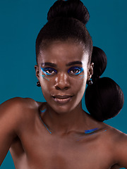 Image showing Portrait, makeup and hair care with a black woman in studio on a blue background for natural cosmetics. Face, beauty and contemporary fashion with a beautiful female model posing for trendy style