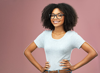 Image showing Portrait, smile and black woman with glasses akimbo in studio isolated on a pink background. Natural beauty, nerd and African female model from Nigeria with confidence, cosmetics and face mockup.