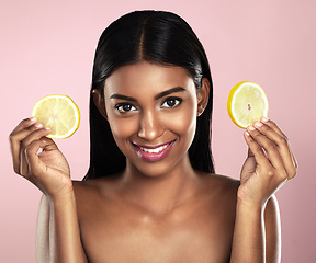 Image showing Face, skincare and happy woman with orange slices in studio isolated on a pink background. Fruit, natural cosmetics and portrait of Indian female model with food for detox, nutrition and vitamin c.