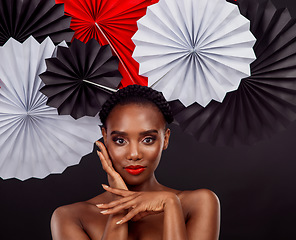 Image showing Origami fans, portrait and a black woman with art for culture isolated on a black background. Creative, makeup and an African model with Japanese traditional art, paper or craft on a studio backdrop