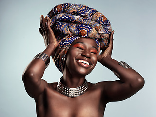 Image showing Beauty, black woman and laughing with African turban and smile in a studio. Isolated, grey background traditional makeup with a young female model with culture crown and fashion with cosmetics