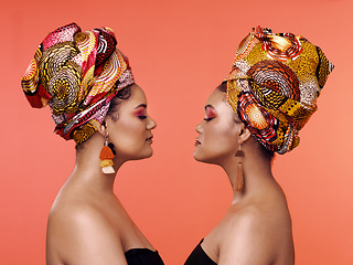 Image showing African fashion, beauty and profile of women on orange background with cosmetics, makeup and accessories. Glamour, luxury and female people with exotic jewelry, traditional style and scarf in studio