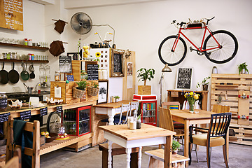 Image showing Space, interior and empty coffee shop with table, chairs and furniture or small business, bistro and cafe with unique design and style. Background, creative startup and food store with bike on wall