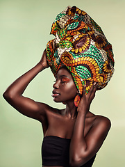 Image showing Culture, fashion and black woman in head wrap in studio for makeup, glow and cosmetics on green background. Face, beauty and african female model with pride, tradition and confidence isolated