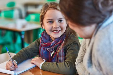 Image showing School, education and a student girl with her teacher in the classroom for learning or child development. Study, writing and smile with a happy young female pupil in class with a woman educator