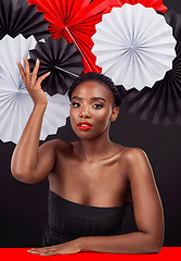 Image showing Portrait, beauty and black woman with origami fans in studio isolated on a dark background. Natural face, makeup cosmetics and skincare of female model with traditional Japanese paper art for culture