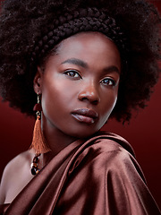 Image showing Natural beauty, face and black woman with fashion in studio isolated on a red background. Portrait, makeup cosmetics and serious African model with stylish outfit, traditional jewelry and aesthetic.