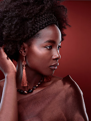 Image showing Thinking, natural beauty and black woman with fashion in studio isolated on a red background. Aesthetic, makeup cosmetics and serious African model with stylish outfit, traditional jewelry or culture