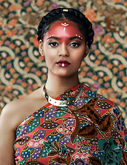 Image showing Makeup, portrait and a woman with fashion for culture isolated on a studio background or wall. Face paint, tribal goddess and a young model with traditional, cultural or clothes for a celebration