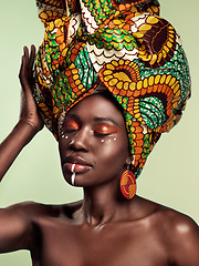 Image showing Culture, beauty and black woman in head wrap in studio with cultural, glow and cosmetics on green background. Face, makeup and African female model with turban, tradition and confidence isolated