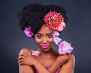 Image showing Flowers, portrait and black woman with makeup in studio for organic beauty on dark background. Floral, face and African lady model smile for eco friendly, natural and cosmetics with isolated mockup