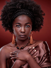 Image showing Portrait, beauty and black woman with traditional fashion in studio isolated on a red background. Natural face, makeup cosmetics and serious African model with stylish outfit, headband and culture.