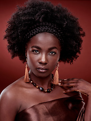 Image showing Beauty, portrait and black woman with fashion in studio isolated on a red background. Face, makeup cosmetics and serious African female model with stylish outfit, traditional earings and jewelry.