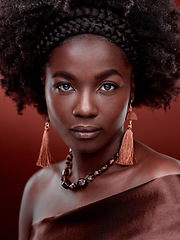 Image showing Face, portrait and black woman with fashion in studio isolated on a red background. Natural beauty, makeup cosmetics and serious African model with stylish outfit, traditional jewelry and culture.