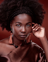 Image showing Portrait, natural beauty and black woman with fashion in studio isolated on a red background. Face, makeup cosmetics and confident African model with stylish outfit, traditional jewelry and culture.