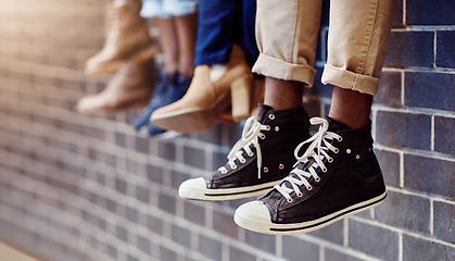 Image showing Brick wall, student sneakers and friends outdoor on university campus together with shoes. Relax, youth and foot at college with people legs ready for education, study and urban feet while sitting