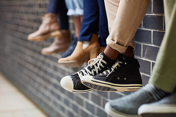 Image showing Brick wall, student sneakers and friends outdoor on university campus together with feet. Relax, urban youth and foot at college with people legs ready for education, study and shoes while sitting