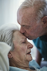 Image showing Senior, kiss and couple in hospital for love, visiting sick cancer patient and hope for recovery. Clinic, elderly man and woman kissing on forehead for empathy, kindness and support for healthcare.