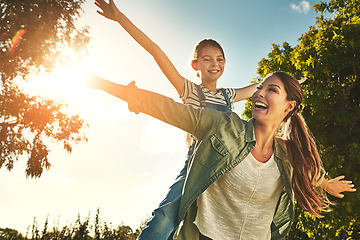 Image showing Piggyback, flying and a mother and child in nature for bonding, happiness and love in summer. Laughing, smile and a mom and a girl kid in a park or garden for playing together and quality time