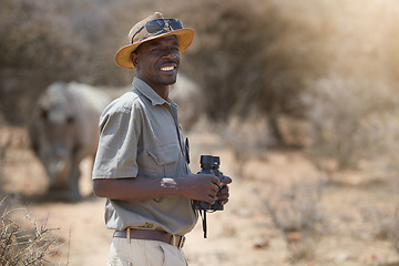 Image showing Portrait, safari and wildlife with a man ranger outdoor in a game park for nature conservation. Animals, binoculars and blurred background with an african male person on patrol in the wilderness