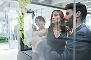 Image showing Glass wall, teamwork and business people planning, strategy and brainstorming in office workplace. Sticky notes, board and collaboration of employees for working on ideas, schedule and discussion.