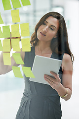 Image showing Tablet, glass wall and business woman writing, planning and strategy in office workplace. Sticky notes, brainstorming and female professional with technology for working on ideas, schedule and info.