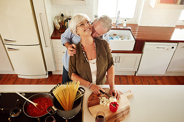 Image showing Kiss, hug or old couple cooking food for a healthy vegan diet together with love in retirement at home. Smile, romance or elderly husband kissing or hugging senior woman in house kitchen at dinner