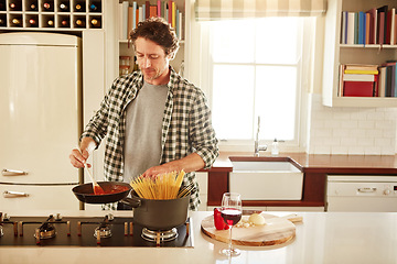 Image showing Food, cooking or mature man in kitchen with healthy vegan diet for nutrition or wellness at home in Australia. Wine glass, spaghetti or male person in house kitchen in preparation for dinner meal