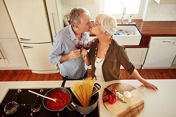 Image showing Kiss, wine toast or old couple cooking food for a healthy vegan diet together with love in retirement at home. Top view of senior woman drinking or kissing in kitchen with mature husband at dinner