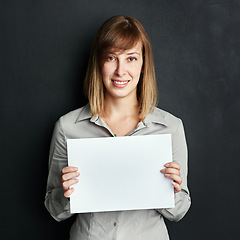 Image showing Portrait, poster and mock up with a woman in studio on a dark background holding a blank sign. Announcement, information or advertising with a female brand ambassador showing empty space on a placard