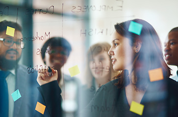 Image showing Business people, glass wall and woman writing, brainstorming and strategy in office. Sticky notes, planning and group of employees working on ideas, schedule and collaboration for teamwork at work.