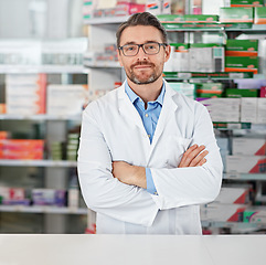 Image showing Success, crossed arms and portrait of pharmacist in pharmacy clinic standing with confidence. Healthcare, medical and mature male chemist by the counter of pharmaceutical medication store dispensary.