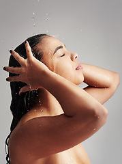 Image showing Shower, washing hair and profile of woman with water in studio for wellness, cleaning and grooming. Beauty, bathroom and face of female person for hygiene, body care and cleansing on gray background