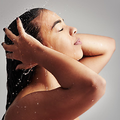 Image showing Shower, washing hair and face of woman with water in studio for wellness, cleaning and grooming. Beauty, bathroom and profile of female person for hygiene, self care and cleansing on gray background