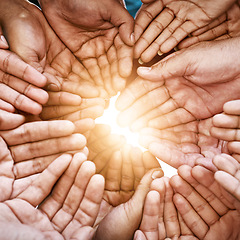 Image showing Closeup, hands and teamwork with collaboration, partnership and charity with sun flare. Group, people or volunteers with sunshine, friends and goals with help, hope and community with support or palm