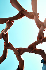 Image showing Hands, link and circle with team and blue sky with low angle, solidarity and trust with arm chain and people together. Teamwork, motivation and connection with group collaboration and community