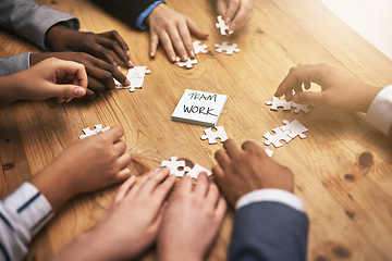 Image showing Teamwork, puzzle and hands of business people in collaboration in a meeting together planning strategy at work. Circle, professional and group in a table with synergy as a workforce for innovation