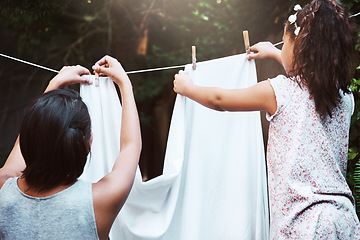 Image showing Help, hanging laundry and a mother and child doing housework, chores and busy with clothes. Cleaning, family and back of a little girl helping mom with clothing on the line in the backyard together