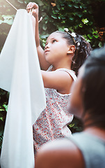 Image showing Hanging clothes, help and a child with mother for laundry, housework and chores together. Teamwork, cleaning and a little girl helping mom at the clothing line for responsibility in the backyard