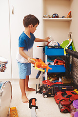 Image showing Home, toys and boy playing, relax and learning with development, happiness and organized. Male child, kid or young person with games, playful and growth in a room, cleaning or creativity in a bedroom