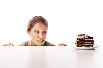 Image showing Hungry, temptation and a woman with chocolate cake on a table isolated on a white background in a studio. Unhealthy, sneaky and a young lady looking at a dessert while on a diet or healthy lifestyle