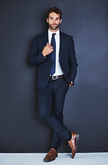 Image showing Portrait, fashion and a formal business man in studio on a blue background for contemporary corporate style. Success, professional and a confident young male employee in a suit for executive power