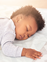 Image showing Tired, bed and baby sleeping in home on blanket for rest, nap time and dreaming in nursery. Childcare, newborn and cute, adorable and African child in bedroom sleep for comfort, relaxing and calm