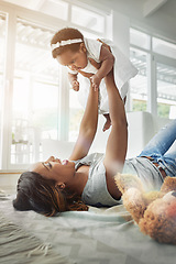 Image showing Bonding, black woman and baby playing on floor with love, happiness and happy time together in living room. Smile, mother and daughter in playful embrace, laughing parent and newborn in family home.