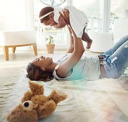 Image showing Laughing black woman, baby and playing on living room floor with love, toys and happiness in bonding together. Smile, mother and daughter in happy embrace, quality time for parent and newborn in home